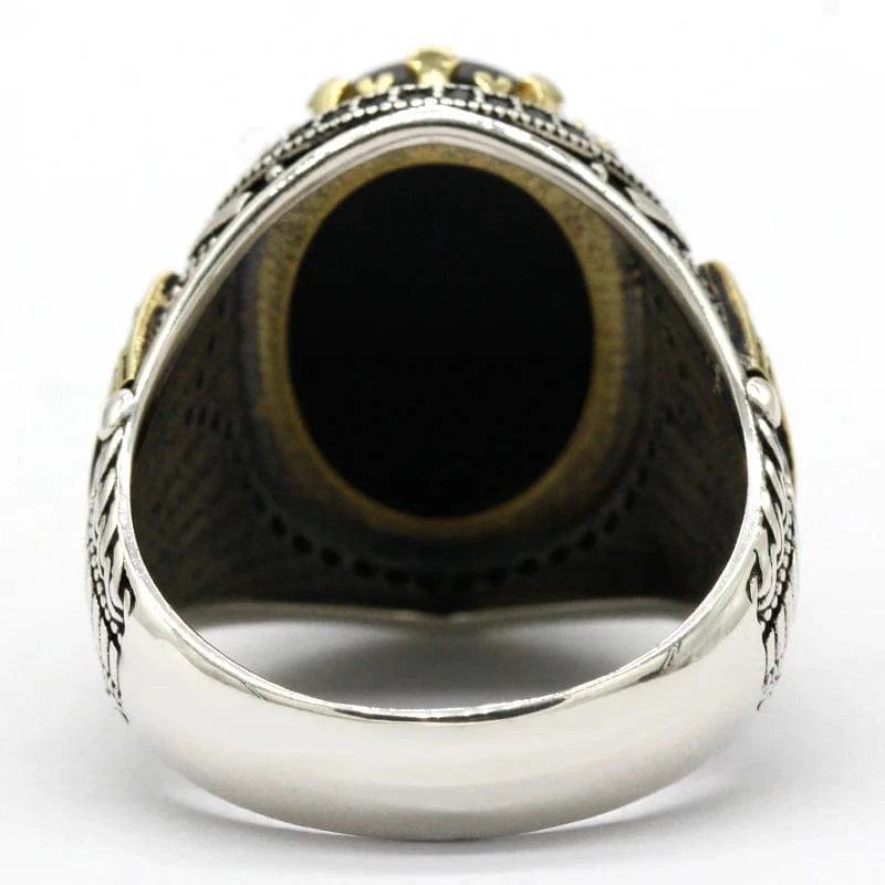 Silver ring with black stone on a white background