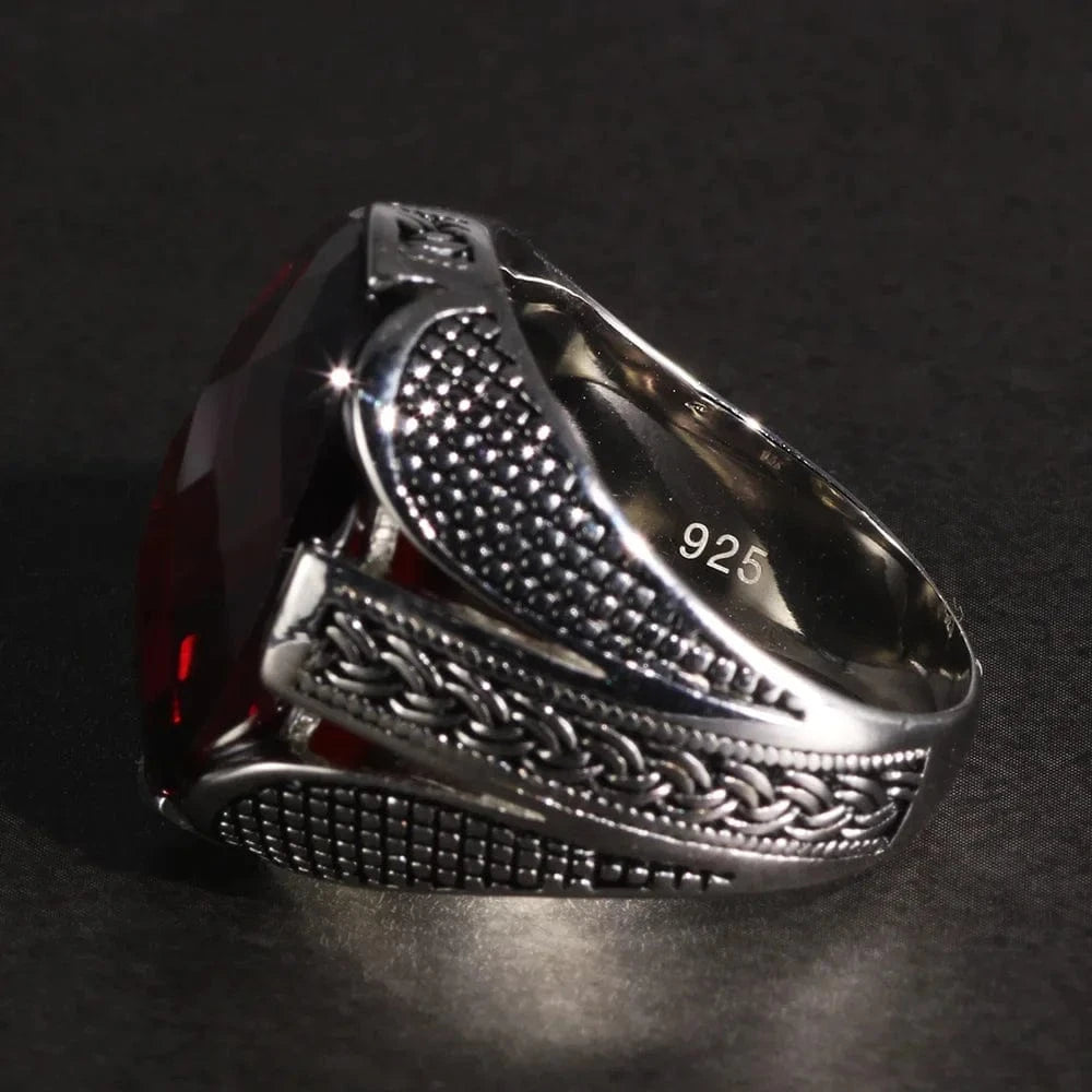 Silver ring with red stone on a dark background