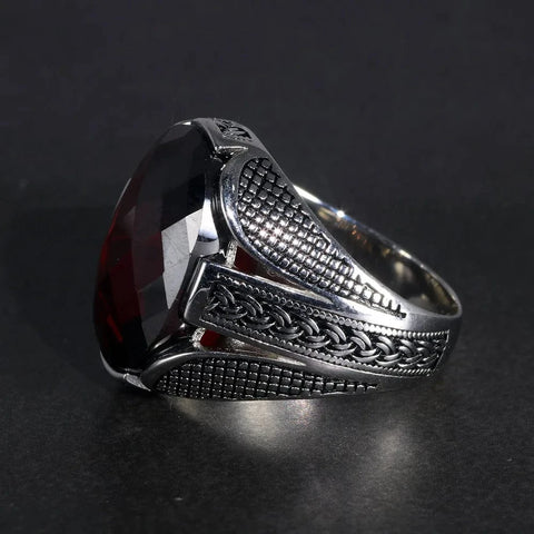 Image of Silver ring with a prominent red stone on a dark background