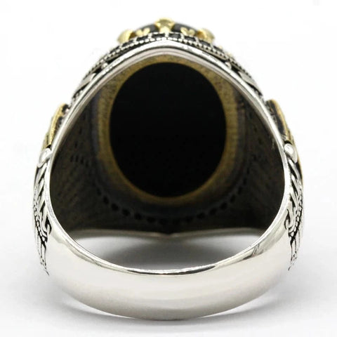 Image of Silver ring with black stone on a white background