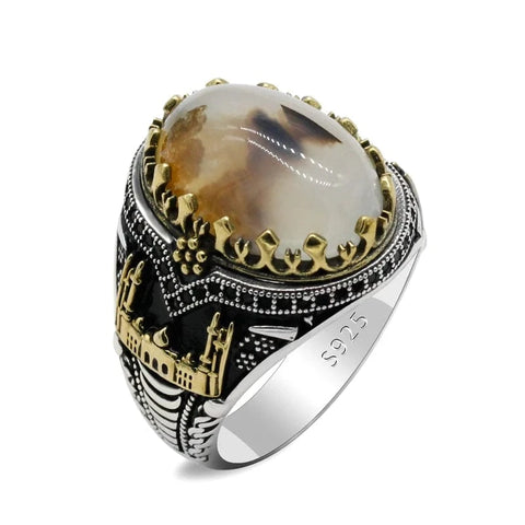 Image of Silver ring with a large amber-colored stone and gold accents on a white background