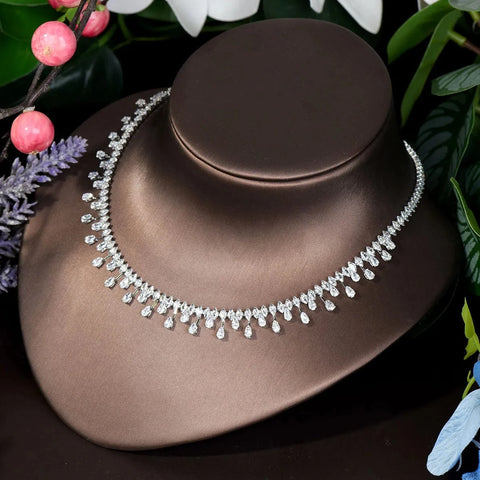 Image of Silver necklace on a brown mannequin bust with flowers in the background